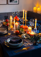 Autumnal table setting with pumpkins and candlelight