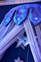 Decorative canopy made of blue fabric with star pendants
