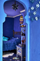 Oriental bedroom in blue with metal bed and lanterns