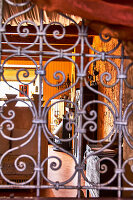 View through artistically designed iron grille into rustic living room