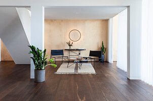 Modern seating area with dark wooden floor and indoor plants