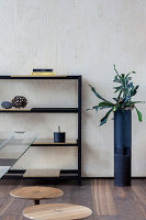 Metal shelf and planter in a modern living room in front of wood panelling