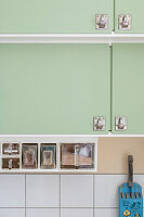 Green kitchen cabinets with practical storage containers