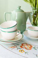 Vintage crockery from the 1940s with floral embroidery on the tablecloth