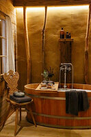 Rustic bathroom with wooden bathtub and Tyrolean wooden chair