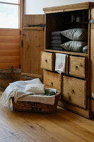 Rustic wooden cabinet with grey towels and cushions