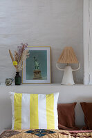 Ablage mit Bilderrahmen, Tischlampe und Trockenblumen