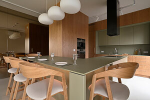 Modern kitchen with wooden units and island in olive green