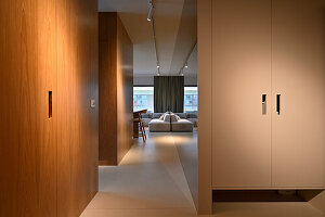 Wood-panelled hallway with view into minimalist living room