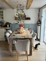 Rustic wooden table in the dining room with autumn decorations and cat