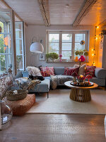 Cosy living room with wooden ceiling and colourful cushions on a light blue sofa