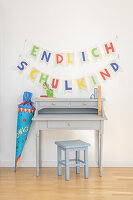 Garland of book pages and coloured paper over desk with school cone
