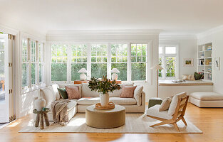 Geräumiges Wohnzimmer mit cremefarbenem Sofa und großen Fenstern