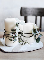 Dekorative Kerzen umwickelt mit Eukalyptuszweigen