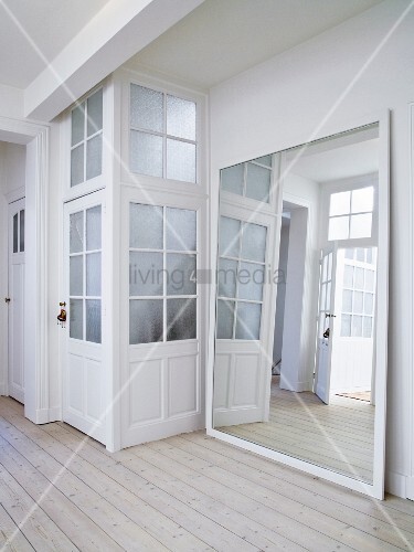 Large Framed Mirror Leaning Against Wall Next To Doors With Latticed Large Framed Mirror Leaning Against Wall Next To Doors With Latticed Gl Panels In Foyer