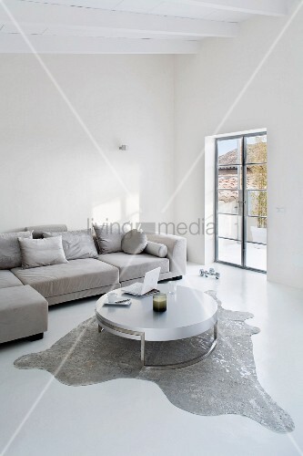 Puristisches Wohnzimmer in Grau/Weiss mit Designertisch auf Tierfell ... Puristisches Wohnzimmer in Grau/Weiss mit Designertisch auf Tierfell ...