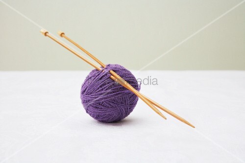 Knitting needles stuck through ball of … – Buy image – 11228284