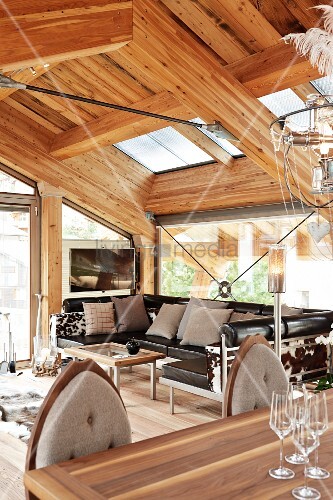 Open-plan interior with leather sofa in modern chalet with exposed ... Open-plan interior with leather sofa in modern chalet with exposed ...