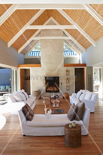 Open-plan interior with sofa set and exposed roof structure with ... Open-plan interior with sofa set and exposed roof structure with ...