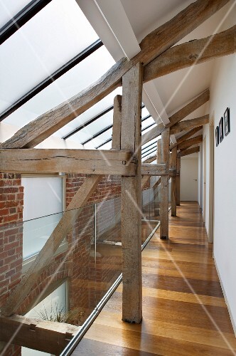 Alte Holzkonstruktion im Flur mit Ziegelwand und Oberlicht in