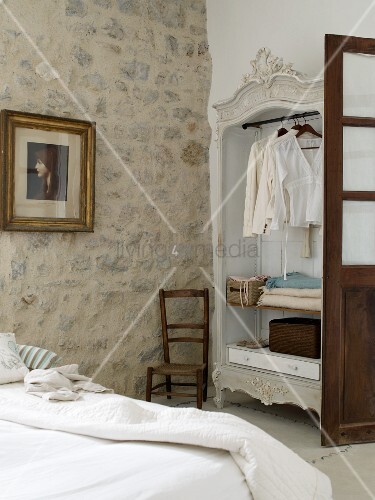 Rustikales Schlafzimmer mit offenem Kleiderschrank und ... Rustikales Schlafzimmer mit offenem Kleiderschrank und ...