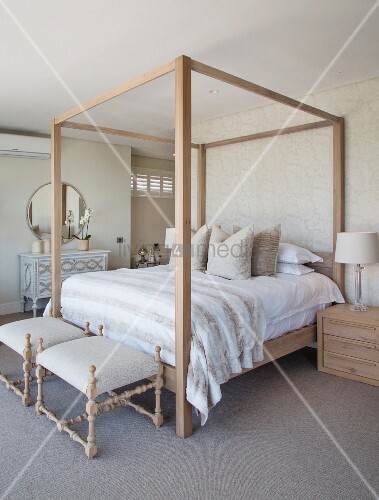 Four Poster Bed Against Patterned Wallpaper And Antique