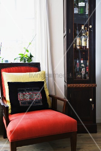A Red Upholstered Armchair With Cushions Buy Image 00707896