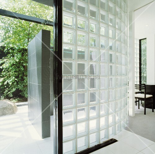 Gebogene Wand aus Glasbausteinen in modernem Haus mit offener Tür ... Gebogene Wand aus Glasbausteinen in modernem Haus mit offener Tür ...